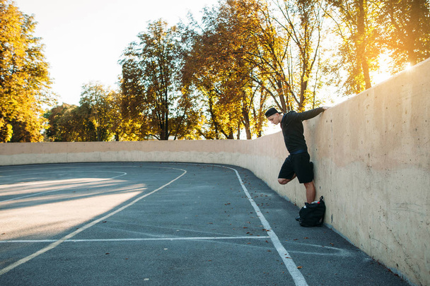 Side view on sportsman stretching near wall - Фото, зображення