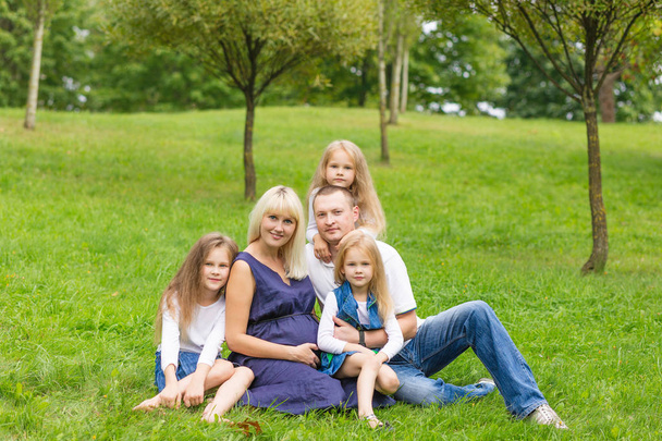 Nuori raskaana oleva äiti perheensä kanssa puistossa
 - Valokuva, kuva