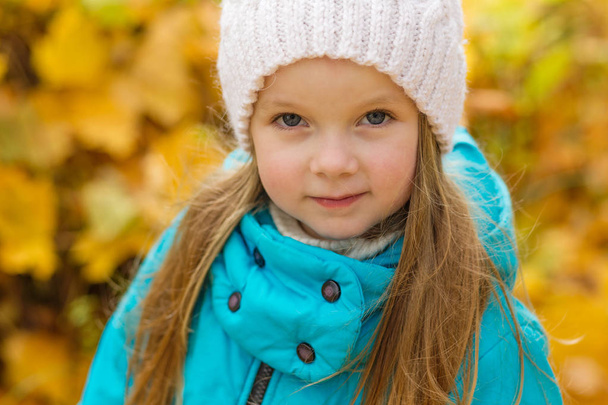 Portrait of a beautiful girl in a blue coat outdoors in autumn - Photo, Image