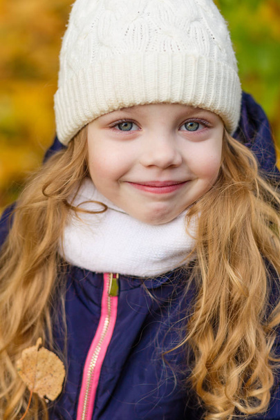 Portrait of a beautiful girl in a blue coat outdoors in autumn - Foto, Bild