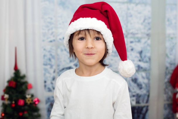 Christmas portrait of cute little preschool boy, eating cookies  - Photo, image