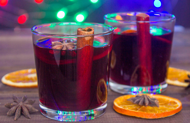 Mulled wine and spices on the background with christmas garland lights - Zdjęcie, obraz