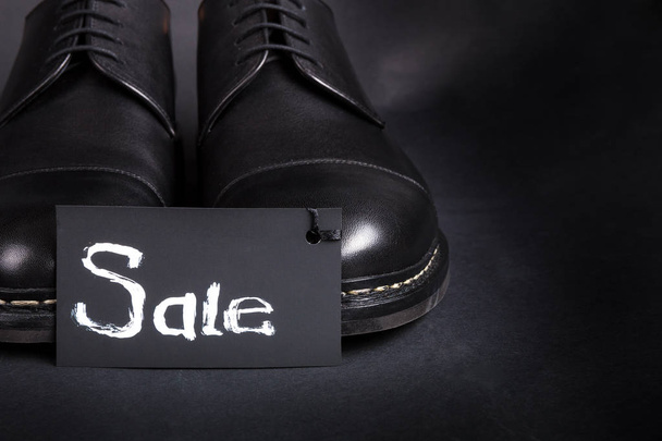 Sale sign. Black oxford shoes on  background. Back view. Copy space. - Foto, Imagen