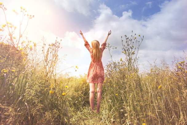 jonge vrouw ontspannen met armen verhoogd tot de hemel in het midden van de natuur - Foto, afbeelding