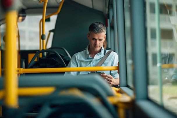 Businessman traveling by bus - Фото, изображение