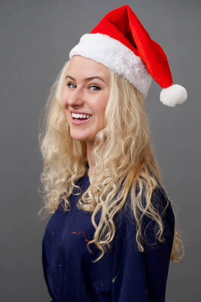 Young blonde woman in a christmas cap - Fotó, kép