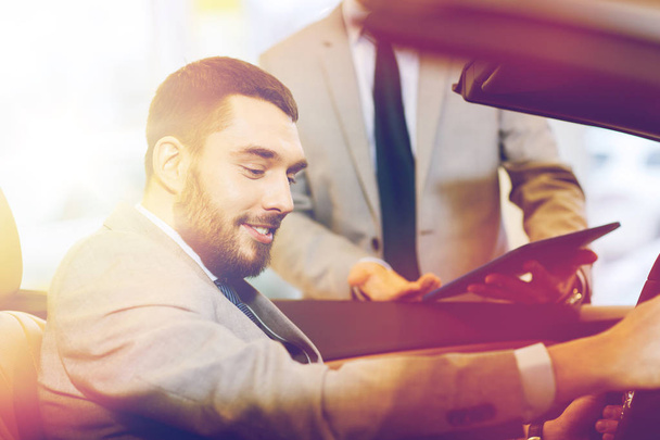 happy man with car dealer in auto show or salon - Valokuva, kuva