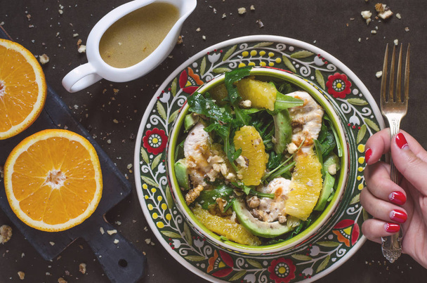 Salade met rucola, avocado sinaasappel kip en honing dressing   - Foto, afbeelding