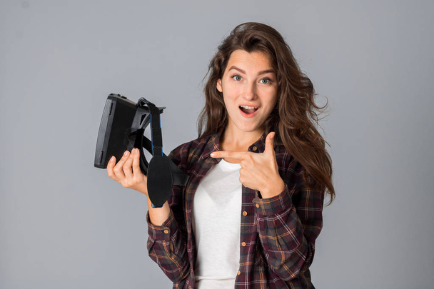 cheerful young brunette girl testing virtual reality glasses - Fotó, kép