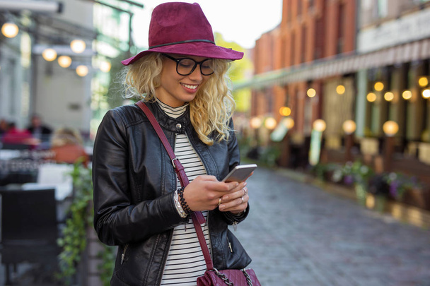 Vrouw op de straat en SMS - Foto, afbeelding