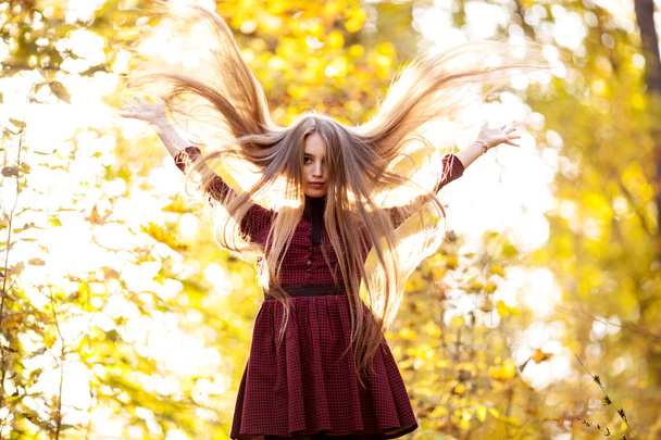 Joven hermosa chica con el pelo largo en el día de otoño en el parque
 - Foto, Imagen
