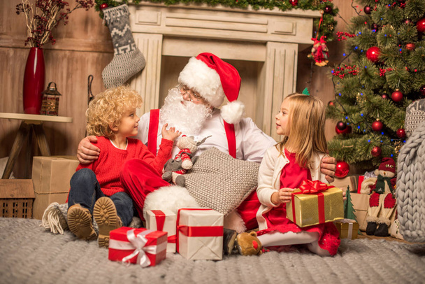 Santa Claus and children with Christmas gifts - Photo, Image