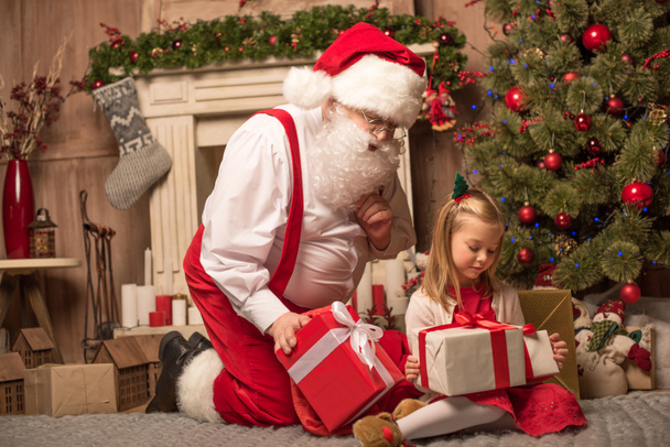 Santa Claus showing Christmas presents - Фото, зображення