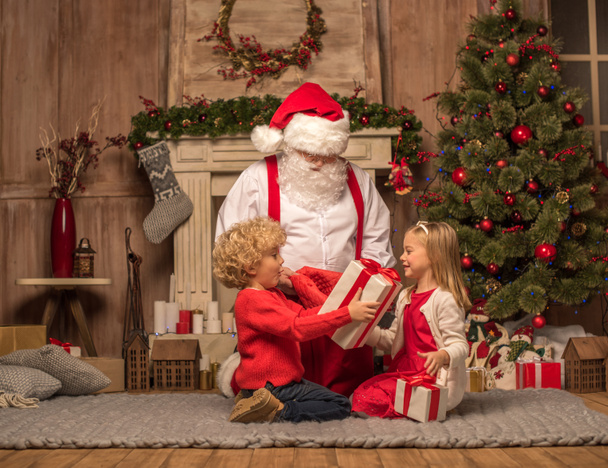 Santa Claus and children with Christmas gifts - Photo, Image
