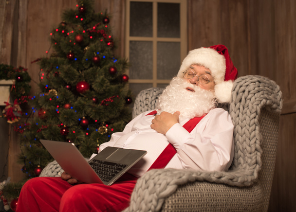 Sleeping Santa Claus with laptop - 写真・画像