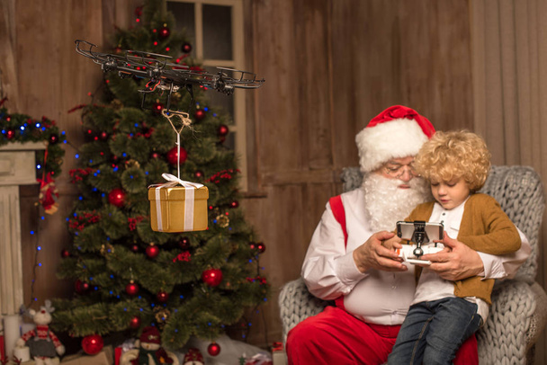Santa met kind met behulp van hexacopter drone  - Foto, afbeelding