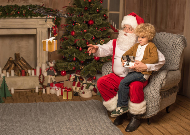 Joulupukki kanssa lapsi käyttäen heksakopteri drone
  - Valokuva, kuva