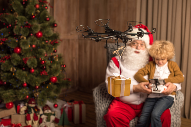 Санта с ребенком с помощью гексакоптера дрона
  - Фото, изображение