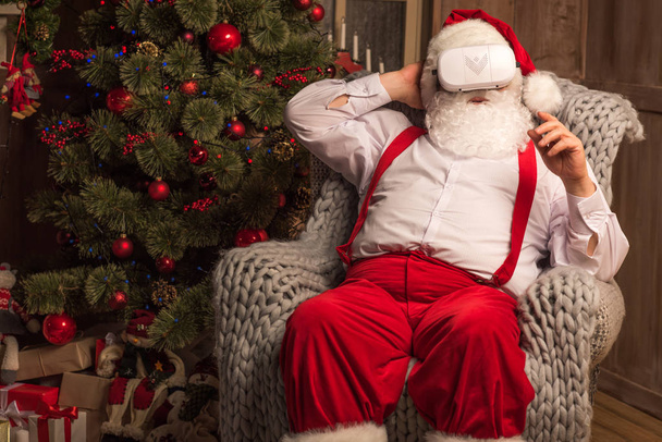 Santa Claus wearing virtual reality headset   - 写真・画像