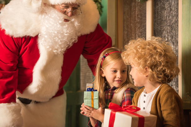 Santa Claus and children with gift boxes  - Fotoğraf, Görsel