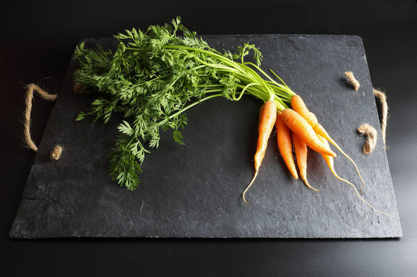 Small baby carrot with green leafs - Foto, Bild