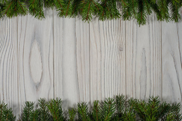 grüne Fichtenzweige auf weißem Holzhintergrund. - Foto, Bild