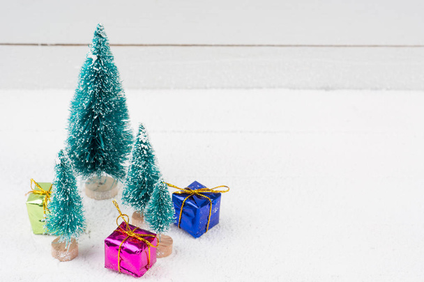 Christmas trees with snow and gift boxes - selective focus - Photo, Image