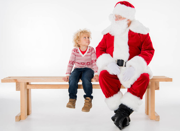 Santa Claus s kid sedí na lavičce   - Fotografie, Obrázek