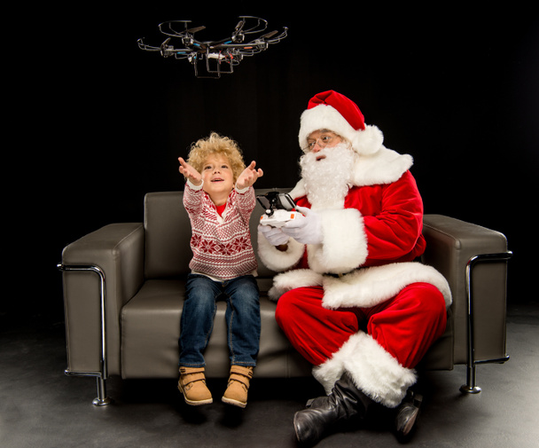 Joulupukki lapsen kanssa käyttäen heksakopteri drone
  - Valokuva, kuva