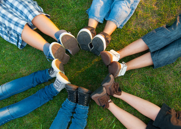 Teini-ikäiset ystävät muodostavat ympyrän jaloillaan
 - Valokuva, kuva