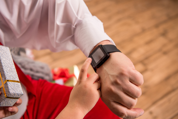 hand with smartwatch and child finger - Foto, afbeelding