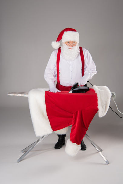 Santa Claus ironing coat - Foto, imagen