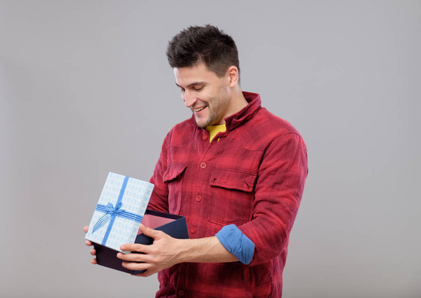 Happy young man with a gift - Valokuva, kuva