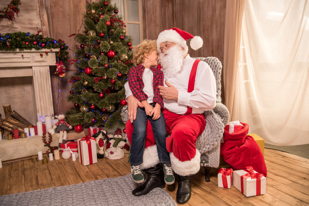 Santa Claus with kid on knee - Фото, зображення