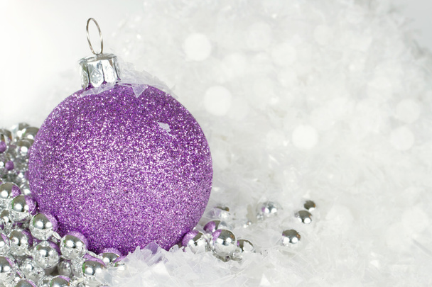 Фиолетовая рождественская безделушка со снежинками и серебряными бусами
 - Фото, изображение