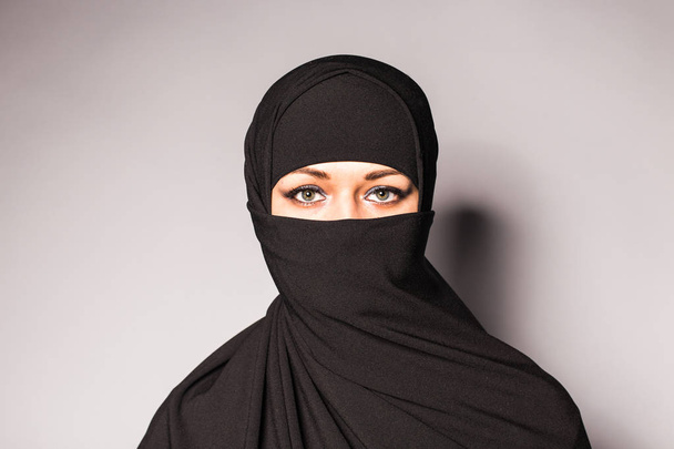 Retrato de una joven árabe con sus hermosos ojos azules en tela islámica tradicional niqab
. - Foto, Imagen