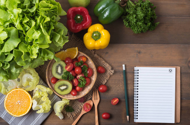 verduras y frutas con cuaderno sobre fondo de madera
 - Foto, imagen
