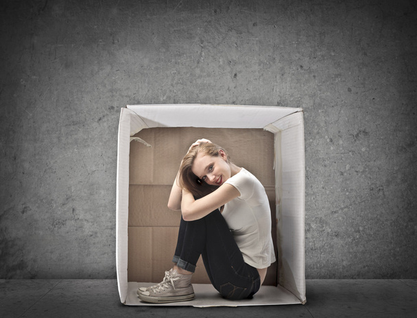 Smiling Blonde Girl Crouched in a Box - 写真・画像