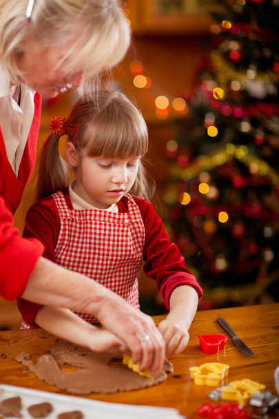 Family time- Grandmother and grandchildren making Christmas cook - Foto, Bild