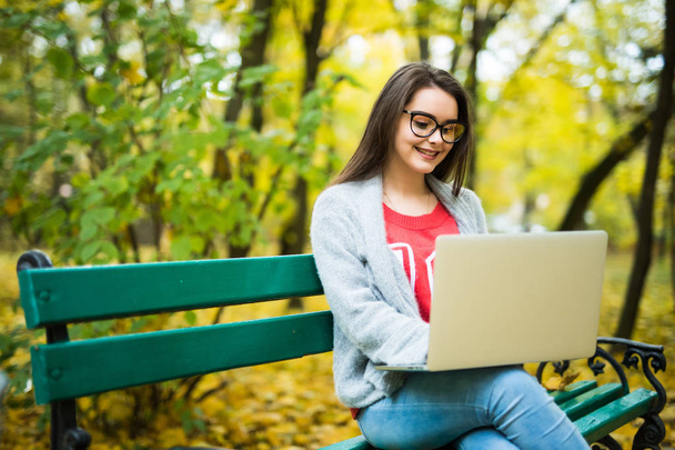 girl students  working on laptop in autumn park - Fotografie, Obrázek