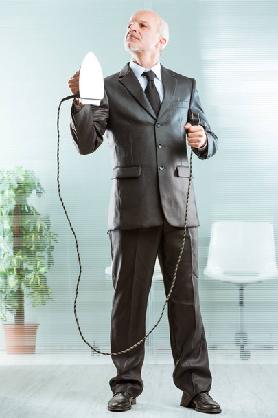 businessman holding a flatiron and posing - Photo, Image
