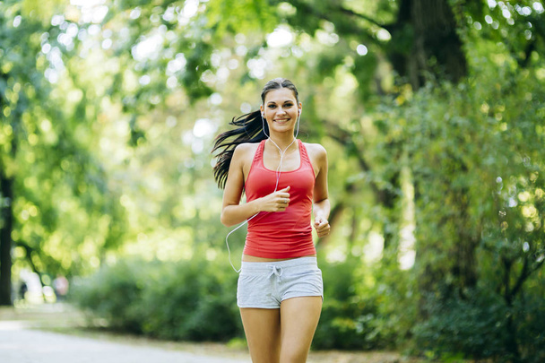 Young beautiful athlete jogging in park - Photo, Image