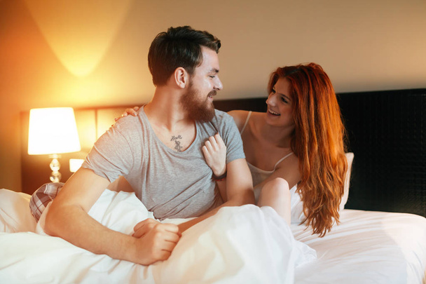 Happy couple in bed showing emotions - Zdjęcie, obraz