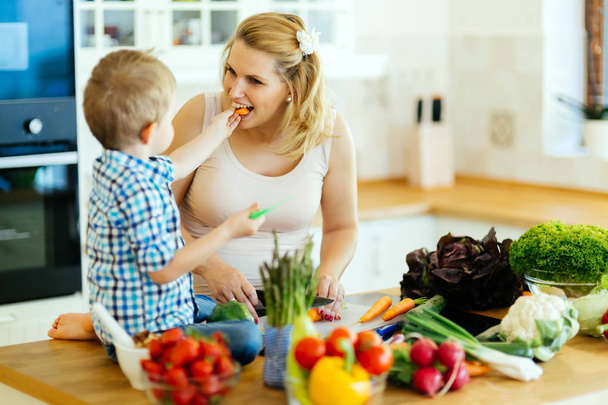 Έγκυος γυναίκα προετοιμασία γεύματος με τον γιο  - Φωτογραφία, εικόνα
