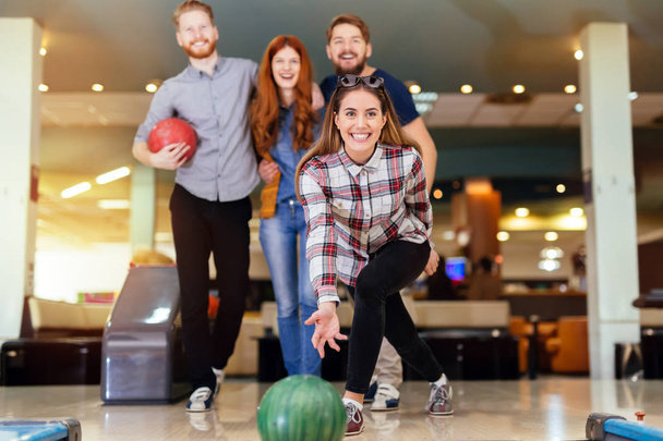 Friends having fun while bowling - Foto, afbeelding