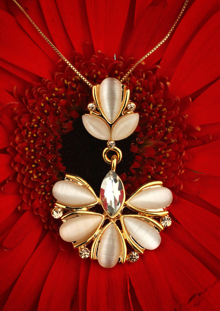 Golden jewellery pendant with diamonds and nacre on flower backg - Foto, imagen