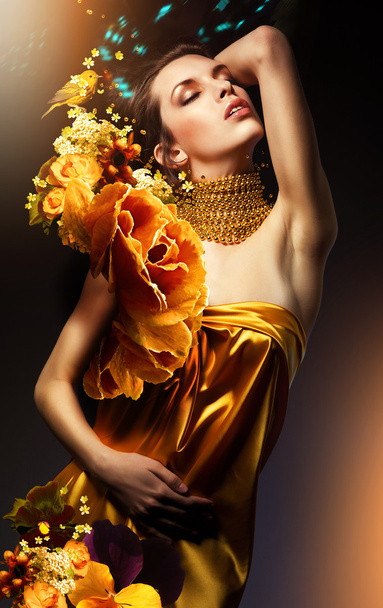 attractive woman in yellow dress with jewelry and flowers - Valokuva, kuva