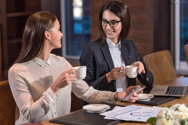 Delighted female colleagues drinking tea in an office - Fotoğraf, Görsel
