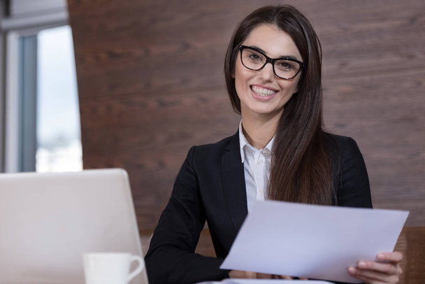 Young woman in glasses working in office - Foto, afbeelding