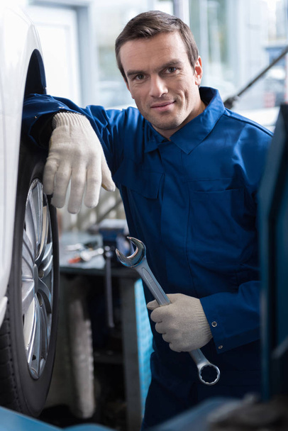 Adult experienced car mechanic working in auto service - Foto, afbeelding